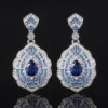 Matching pair baroque fan shaped teardrop simulated sapphire long dangle drop earrings isolated black reflective background