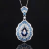 Individual baroque fan teardrop simulated sapphire pendant necklace rhodium silver plated isolated reflective background