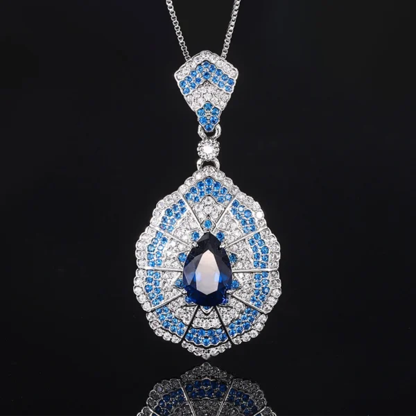 Individual baroque fan teardrop simulated sapphire pendant necklace rhodium silver plated isolated reflective background