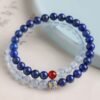 Side view of the "Blue Wisdom" lapis lazuli and aquamarine bracelet, showing the arrangement of gemstones and enamel charm