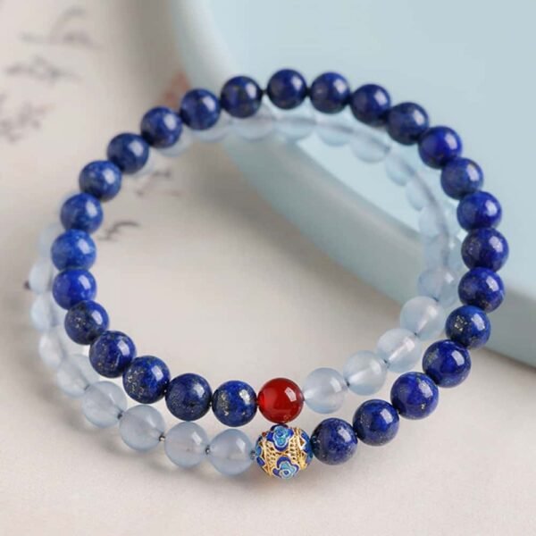 Side view of the "Blue Wisdom" lapis lazuli and aquamarine bracelet, showing the arrangement of gemstones and enamel charm