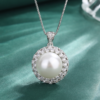 Macro close-up shot double halo cubic zirconia surrounded round pearl pendant necklace on textured green fabric
