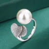 Macro close-up shot double heart pave cubic zirconia imitation pearl open adjustable ring, showing heart inlay detail, pearl surface gloss and open band structure