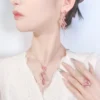 Model wearing complete simulated ruby twist ribbon jewelry set earrings necklace ring full outfit view