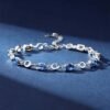 Side view of ocean heart blue crystal bracelet showing the adjustable chain and crystal details on blue background
