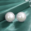 Matching pair double halo cubic zirconia surrounded round pearl stud earrings isolated white background