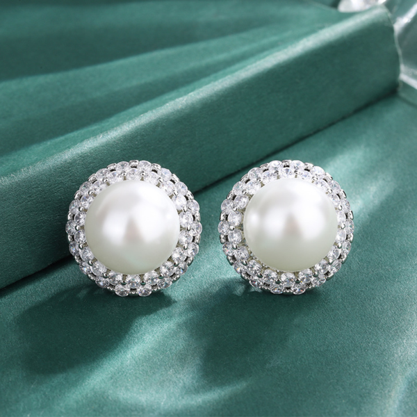Matching pair double halo cubic zirconia surrounded round pearl stud earrings isolated white background