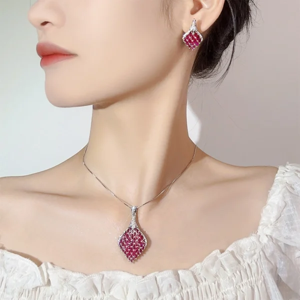 Female model wearing simulated ruby pave phoenix tail jewelry set drop earrings and teardrop necklace real wearing photo