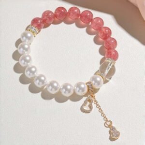 Flat lay view of strawberry quartz bracelet with size details (9-10mm quartz, 10mm pearl, 12mm crystal) on light background