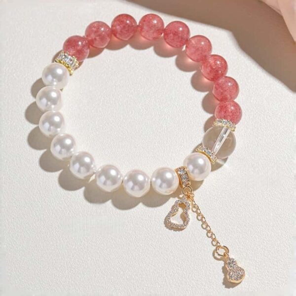 Flat lay view of strawberry quartz bracelet with size details (9-10mm quartz, 10mm pearl, 12mm crystal) on light background