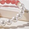 Close-up detail shot of strawberry quartz and imitation pearl beads on a bracelet, showing natural texture and luster