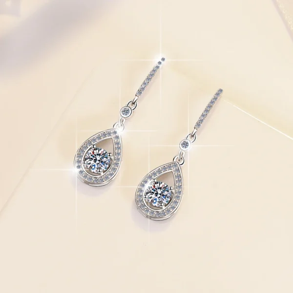 Top-down overhead flat lay photo pair S925 sterling silver 0.5ct moissanite teardrop dangle earrings, fully unfolded symmetrical layout, full hook and pendant detail visible