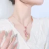 Close up shot of model neck wearing simulated ruby twist ribbon rose gold pendant necklace