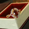 Twisted split shank adjustable ring with oval simulated ruby halo placed inside red lined jewelry box close up photo