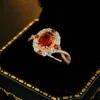 Vintage oval simulated ruby halo twist split shank ring laid inside black trimmed jewelry box studio product photo