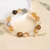 Side detail view of yellow rutilated quartz bracelet highlighting polished beads and exquisite handmade craftsmanship