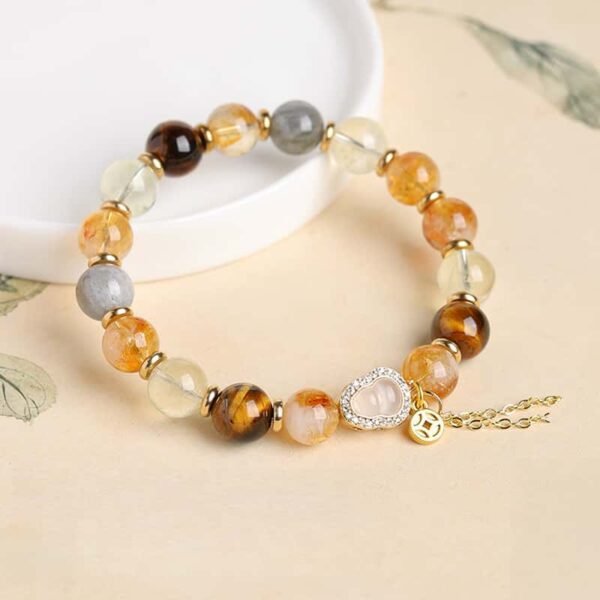 Side detail view of yellow rutilated quartz bracelet highlighting polished beads and exquisite handmade craftsmanship